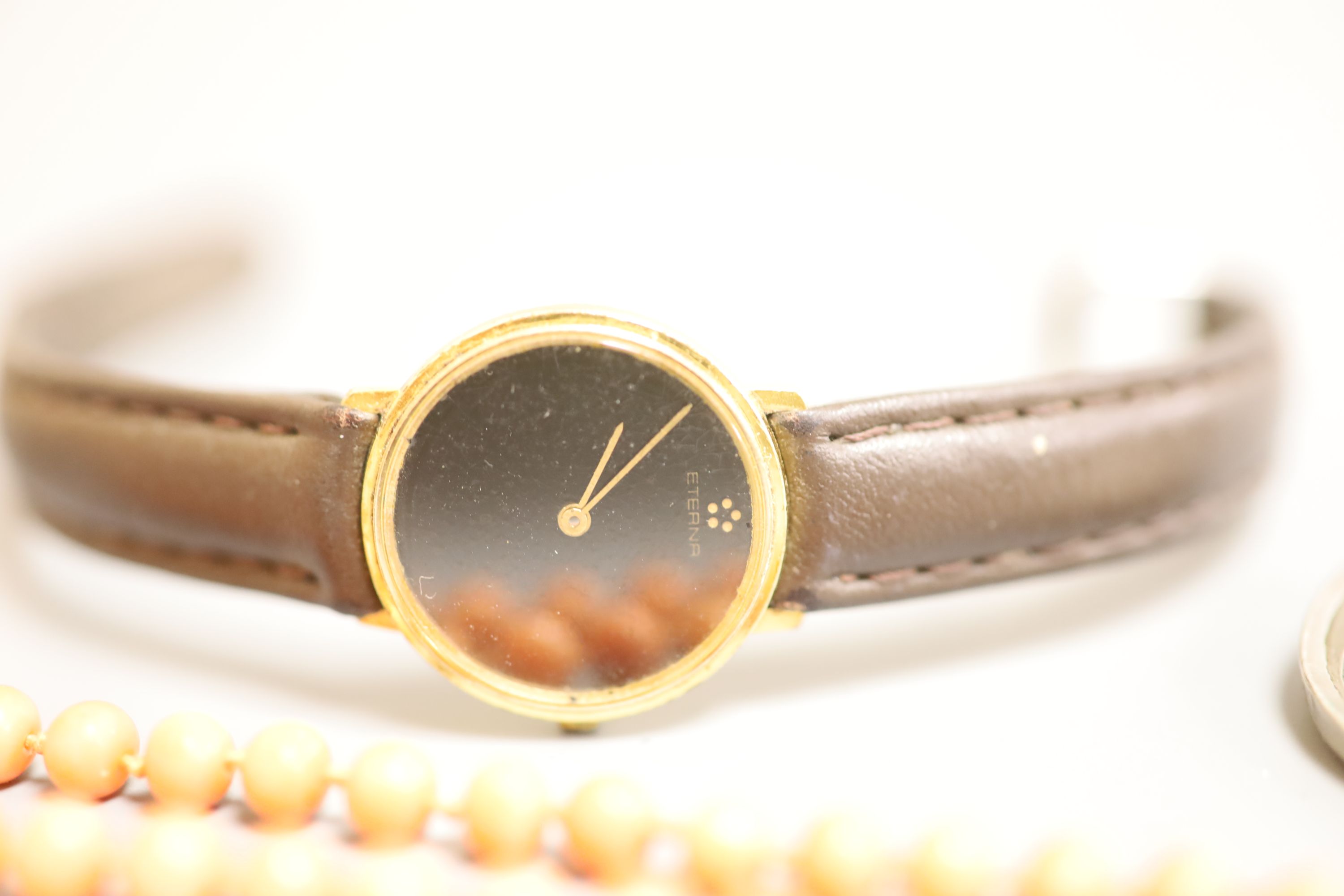 A lady's Longines gold plated and steel quartz wristwatch, one other watch, a coral bead necklace, badges etc.